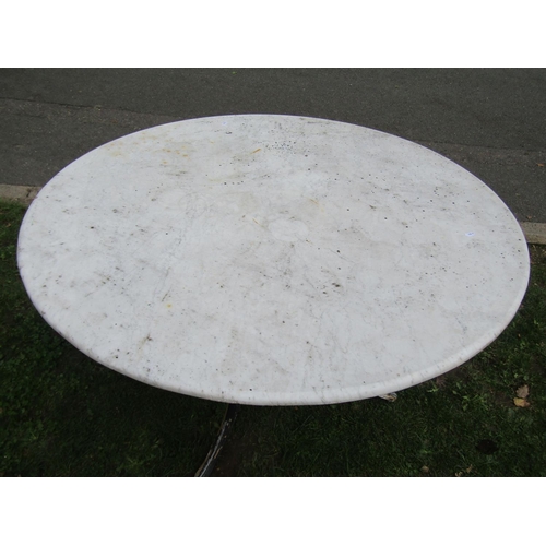 1059 - A weathered garden table the overhanging circular marble top 120 cm diameter raised on a swept cast ... 