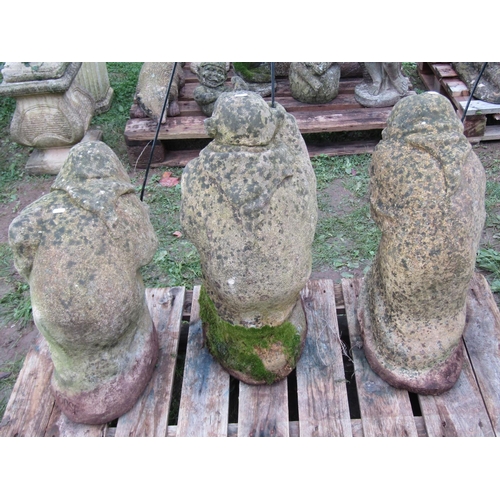 1061 - Three weathered cast composition stone garden ornaments in the form of goblins in varying poses but ... 