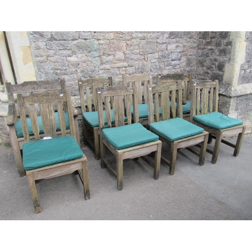 1062 - A set of eight (6&2) weathered heavy gauge teak garden chairs with slatted seats, backs and carved r... 