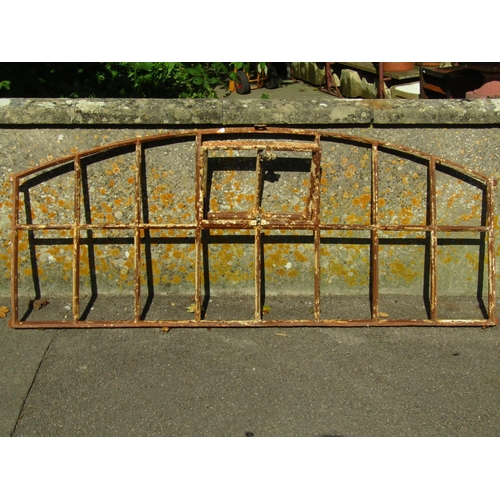 1093 - A reclaimed Georgian cast iron segmented window frame of rectangular and arched form with central op... 