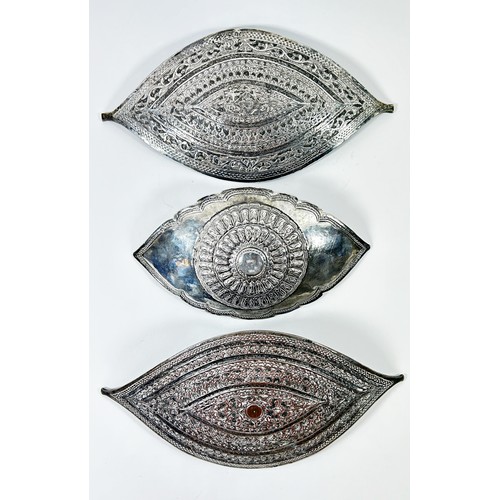 294 - Two Malay Metalware buckles both richly engraved in similar designs, 21 cm x 10 cm together with ano... 