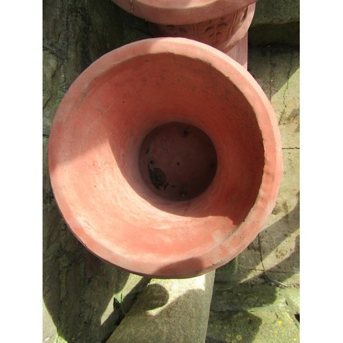 1030 - A pair of cast composition stone trumpet shaped garden urns with faux terracotta finish, relief deta... 