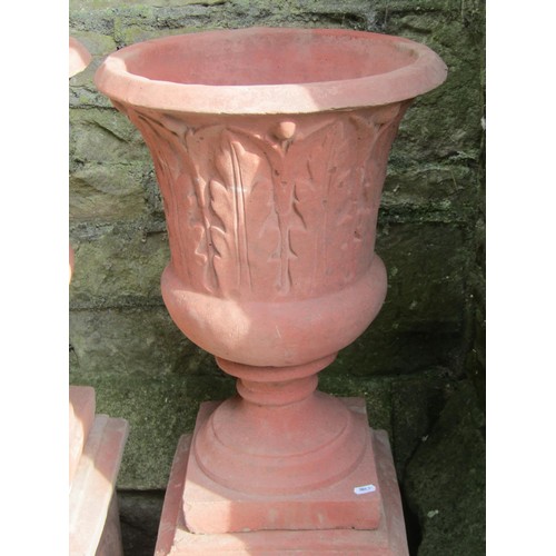 1030 - A pair of cast composition stone trumpet shaped garden urns with faux terracotta finish, relief deta... 