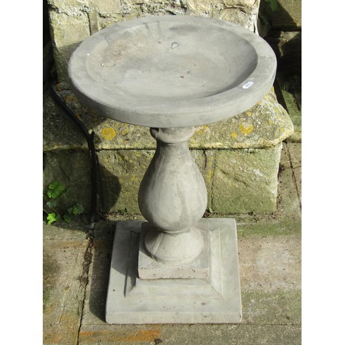 1026 - A cast composition stone three sectional bird bath with circular top raised on a baluster shaped ped... 