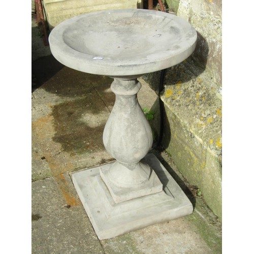 1026 - A cast composition stone three sectional bird bath with circular top raised on a baluster shaped ped... 