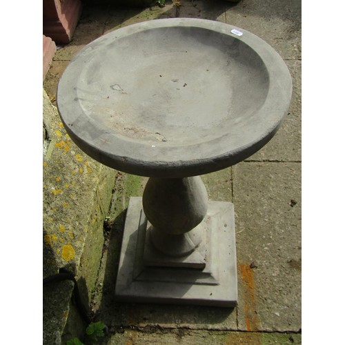 1026 - A cast composition stone three sectional bird bath with circular top raised on a baluster shaped ped... 