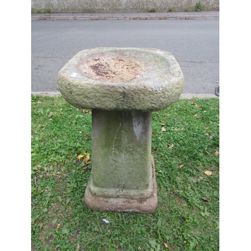 1056 - A weathered cast composition stone bird bath in the form of a shell with pan surmount and raised on ... 