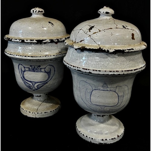 80 - An associated pair of unusual continental tin-glazed drug jars and covers with crude painted detail ... 