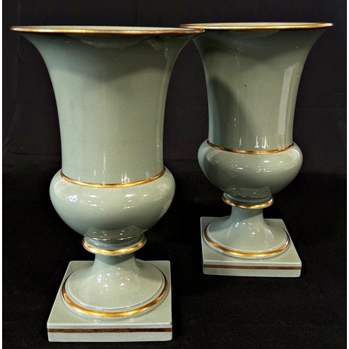 104 - A pair of celadon glazed campana shaped vases with gilded bands, 28cm high