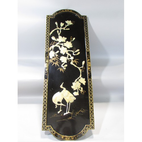 620 - A Japanese decorative black lacquered panel with cranes and cherry blossom in Mother of Pearl relief... 