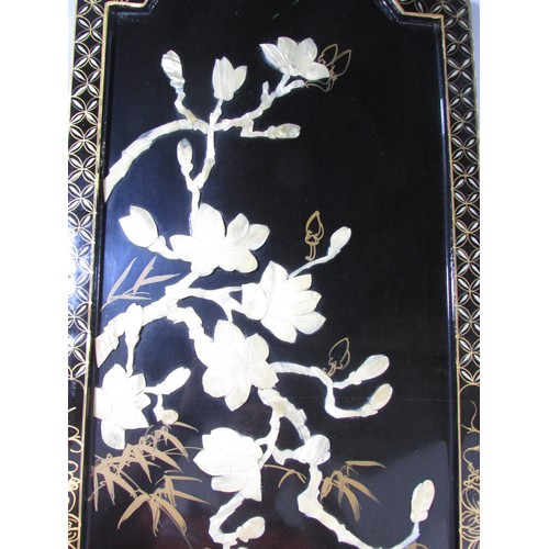 620 - A Japanese decorative black lacquered panel with cranes and cherry blossom in Mother of Pearl relief... 