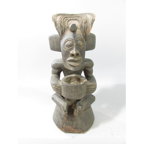 652 - A Chokwe type African wood carving of a figure holding a bowl.33cm high