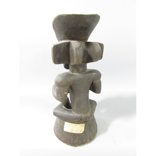 652 - A Chokwe type African wood carving of a figure holding a bowl.33cm high