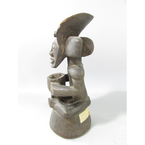 652 - A Chokwe type African wood carving of a figure holding a bowl.33cm high