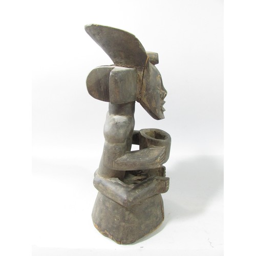 652 - A Chokwe type African wood carving of a figure holding a bowl.33cm high