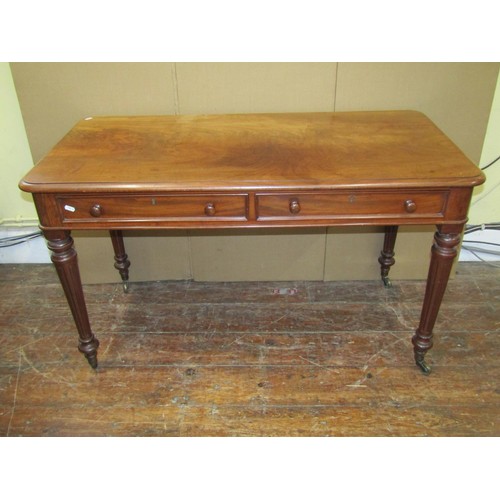 1608 - A 19th century mahogany writing table with two real and two dummy drawers on fluted supports, the si... 