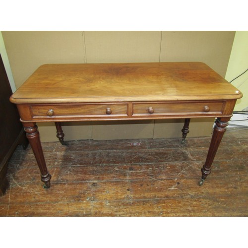 1608 - A 19th century mahogany writing table with two real and two dummy drawers on fluted supports, the si... 