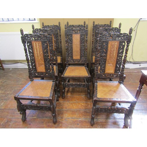 1620 - Set of eight Carolean style dining chairs in oak, with traditional carving and caned panel seats and... 