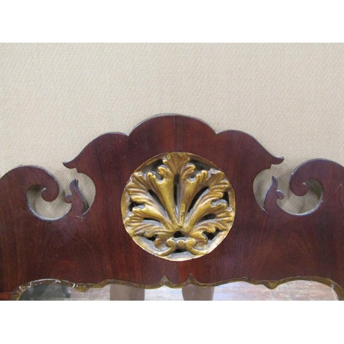 1633 - A Georgian Mahogany wall mirror with shaped and fretted outline and further gilded detail, 63cm wide... 