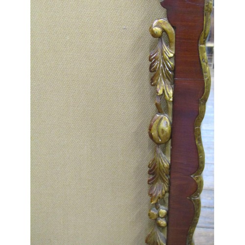 1633 - A Georgian Mahogany wall mirror with shaped and fretted outline and further gilded detail, 63cm wide... 