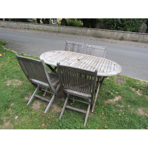 1073 - A weathered teak garden table of oval slatted form, raised on X framed supports, together with four ... 