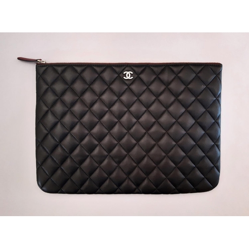 38 - Zipped case marked 'Chanel' in quilted black leather 34x24cm with cloth bag