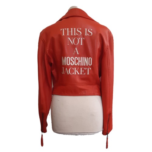 61 - Red leather women's jacket by Moschino with embroidered  writing verso, size 12