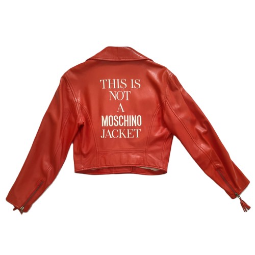 61 - Red leather women's jacket by Moschino with embroidered  writing verso, size 12