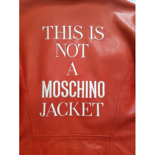 61 - Red leather women's jacket by Moschino with embroidered  writing verso, size 12