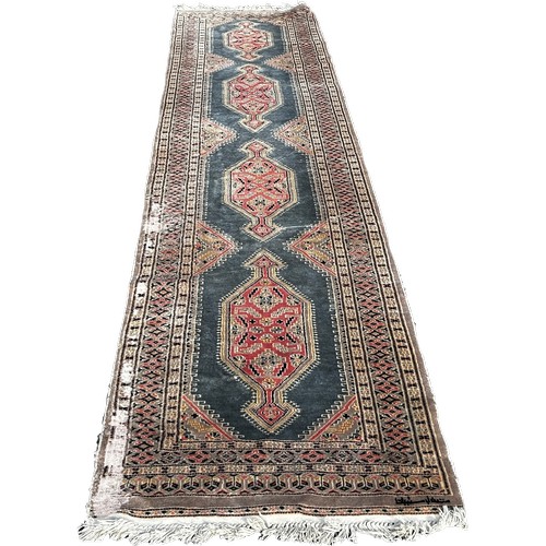 1652 - A Persian runner with four extended lozenges on a pale blur ground, with a signature 370cm by 80cm