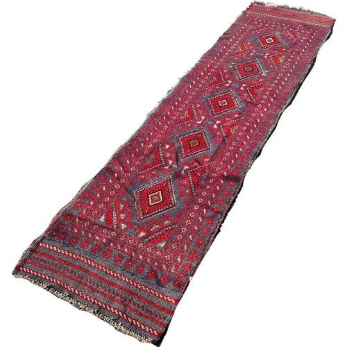 1653 - A Meshwani runner with an all over red and blue diamond pattern, 248cm x 59cm approximately