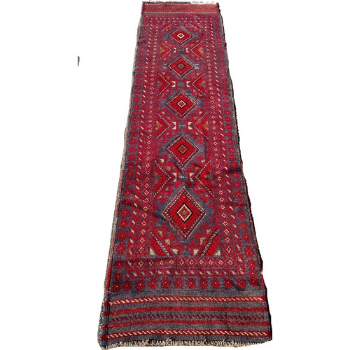 1653 - A Meshwani runner with an all over red and blue diamond pattern, 248cm x 59cm approximately