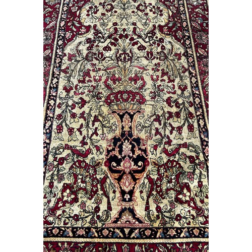 1673 - A fine old Persian carpet with a central vase of flowers set in a prayer arch with further floral de... 