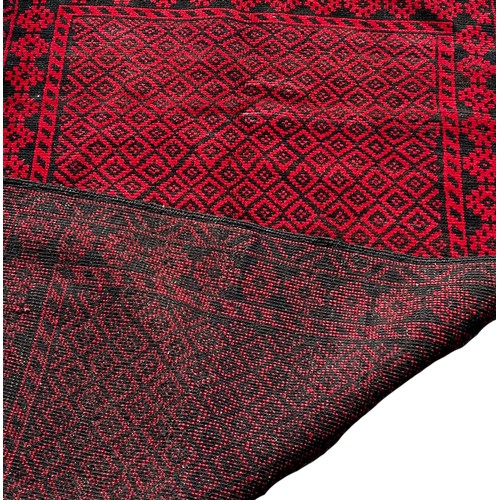 1690 - A Baluchi rug with an all over small red and black diamond, 140cm x 90cm approximately