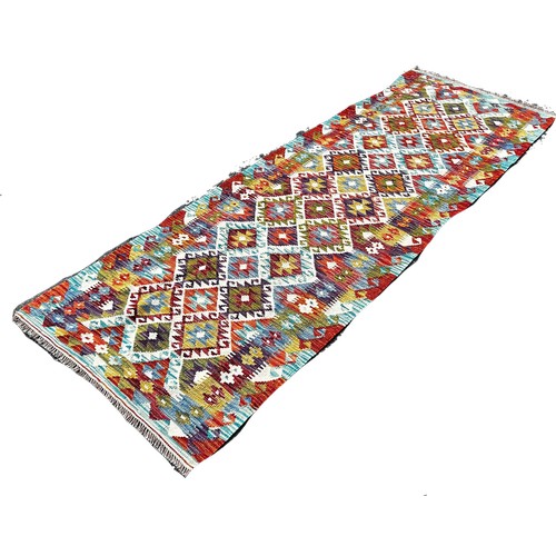 1698 - A Chobi Kilim runner with an all over multicoloured diamond pattern 248cm  x 82cm approximately