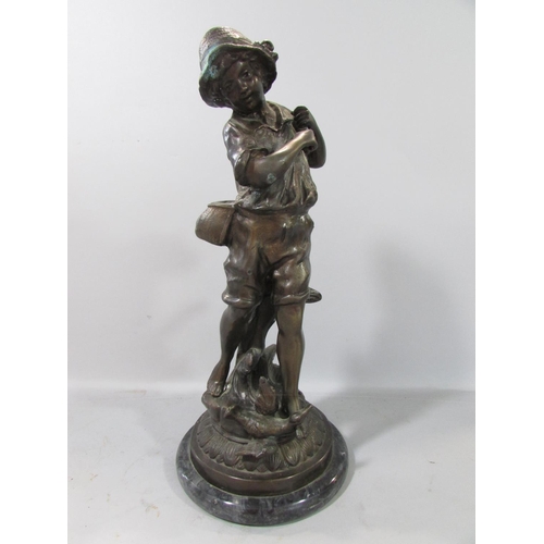 584 - A bronzed study of a country boy and a low flying duck, (missing his stick) raised on a circular mar... 