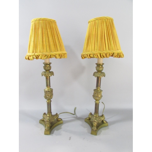 598 - A pair of vintage brass candlestick table lamps on hairy paw supports, with vintage shades 37cm high... 