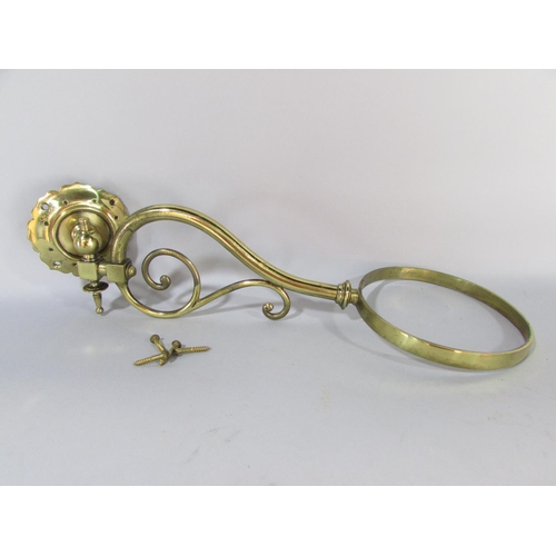 605 - A Victorian brass wall bracketed oil lamp with a crimped Cranberry glass shade and font.