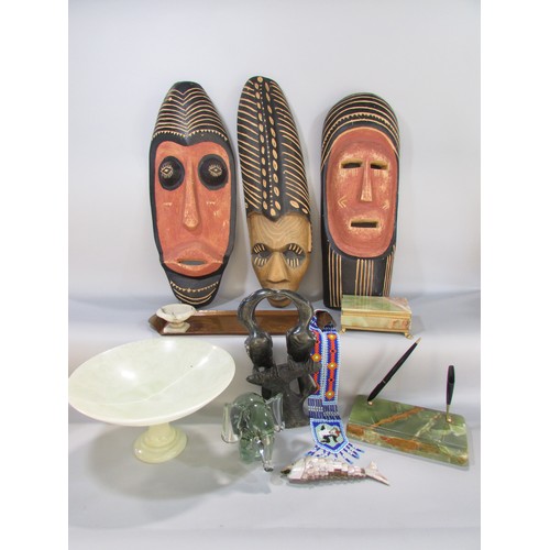 593 - A miscellaneous collection of items including three souvenir type African masks, a glass elephant, o... 