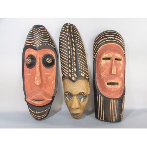 593 - A miscellaneous collection of items including three souvenir type African masks, a glass elephant, o... 