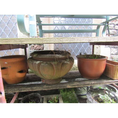 1003 - A weathered terracotta squat oviform garden planter, 34 cm high x 55 cm diameter together with three... 