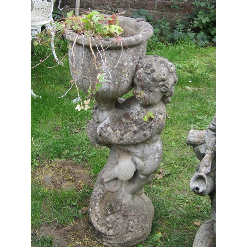 1057 - A weathered cast composition stone garden water feature in the form of a boy standing beside a rusti... 