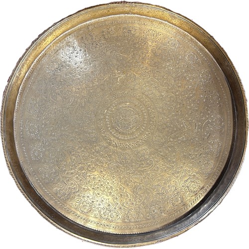 696 - A Middle Eastern circular brass tray with intricately chased leopards and antelopes amongst tight fo... 