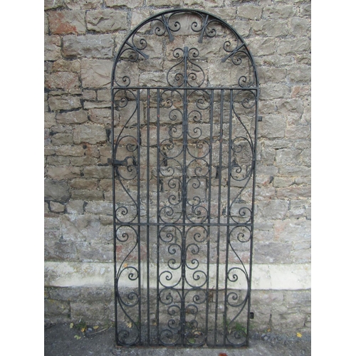 1076 - A vintage heavy gauge ironwork pedestrian side gate of arched form with decorative scroll work detai... 