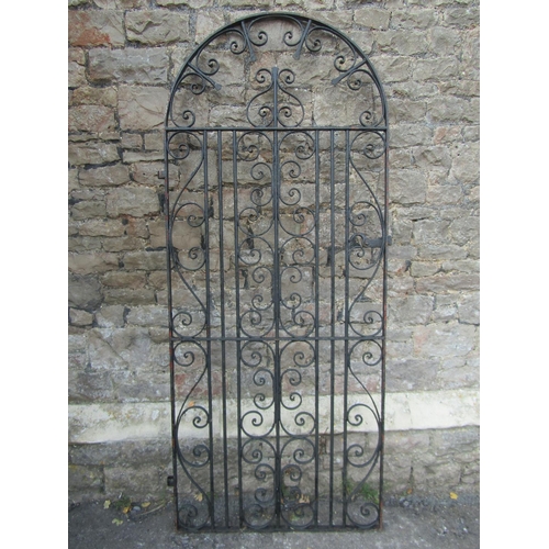 1076 - A vintage heavy gauge ironwork pedestrian side gate of arched form with decorative scroll work detai... 