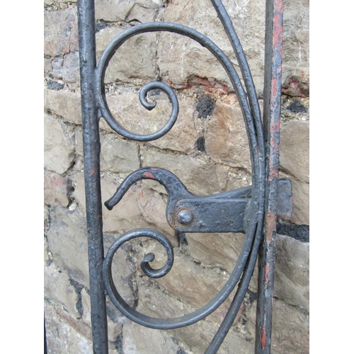 1076 - A vintage heavy gauge ironwork pedestrian side gate of arched form with decorative scroll work detai... 