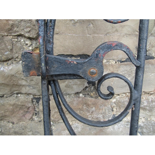 1076 - A vintage heavy gauge ironwork pedestrian side gate of arched form with decorative scroll work detai... 