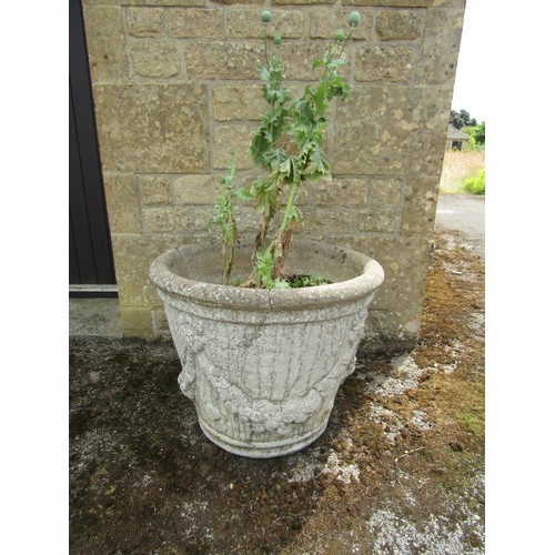 1080 - A pair of weathered cast composition stone planters of tapering cylindrical form with moulded garlan... 