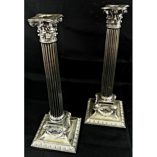 192 - A Pair of early 20th century silver plated Corinthian Column candlesticks raised on garland and rams... 