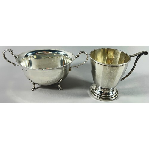 209 - A silver twin handled sugar bowl, a silver cup bearing the name 'Ann', and a weighted posy vase, 9.4... 